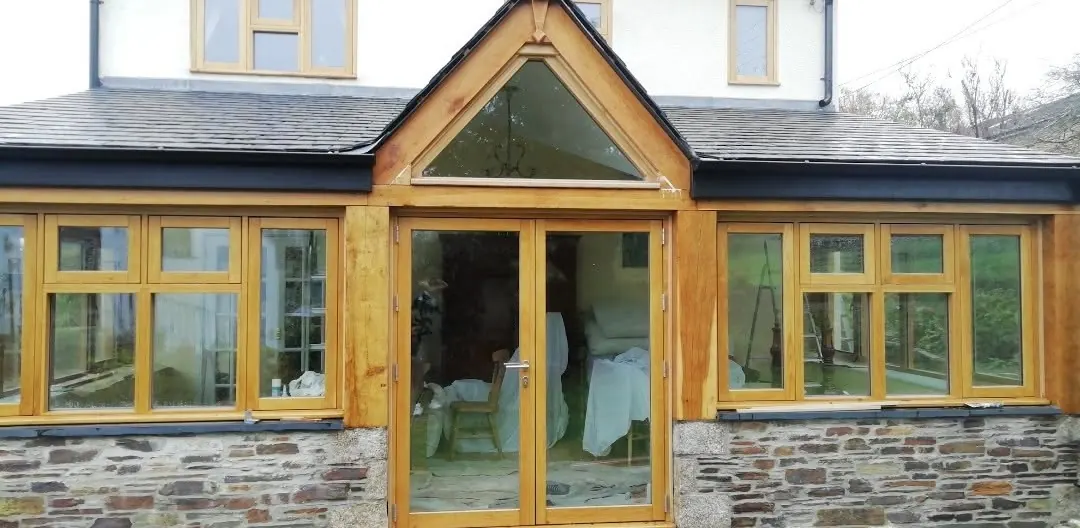 Handmade oak conservatory built from 10x10 oak beams on a stone cottage