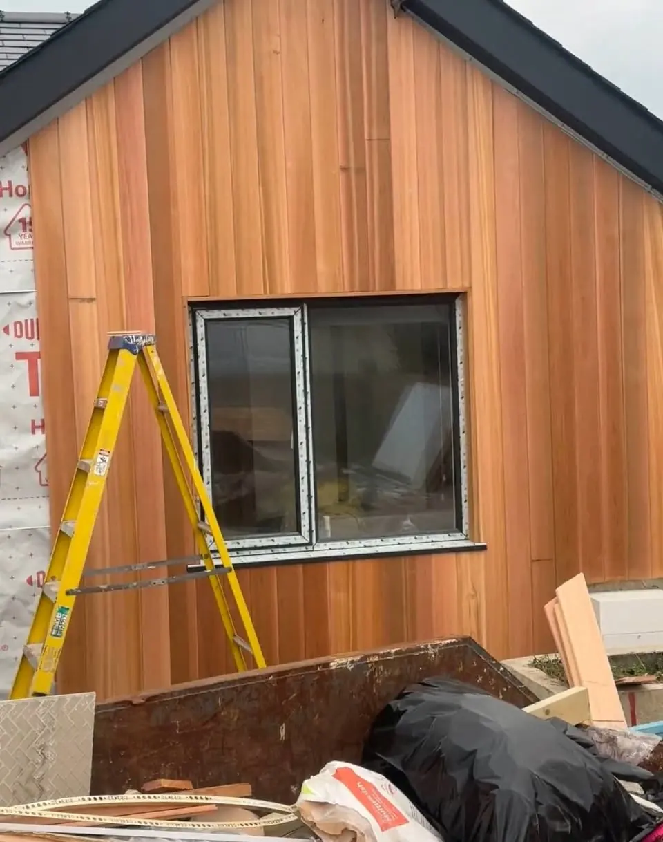 Western red cedar cladding mid-install around a new window