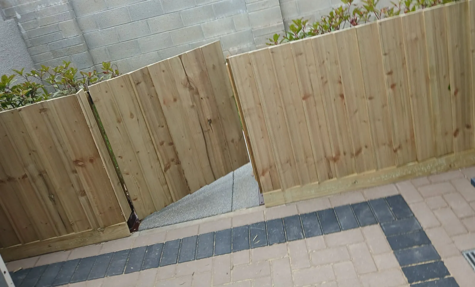 New timber close-board fence panels along a block-paved patio